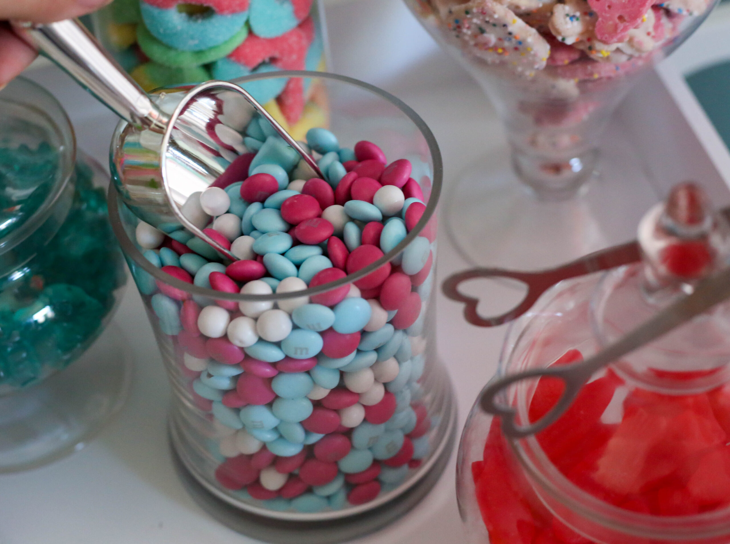 m&ms candy at a candy theme party in a glass candy jar with silvertone scoop