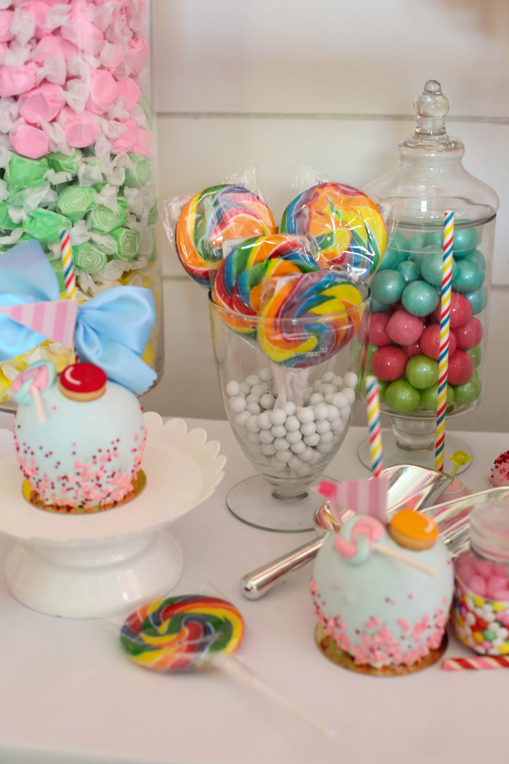 candy jars in a candy buffet display with taffy, lollipops and gumballs