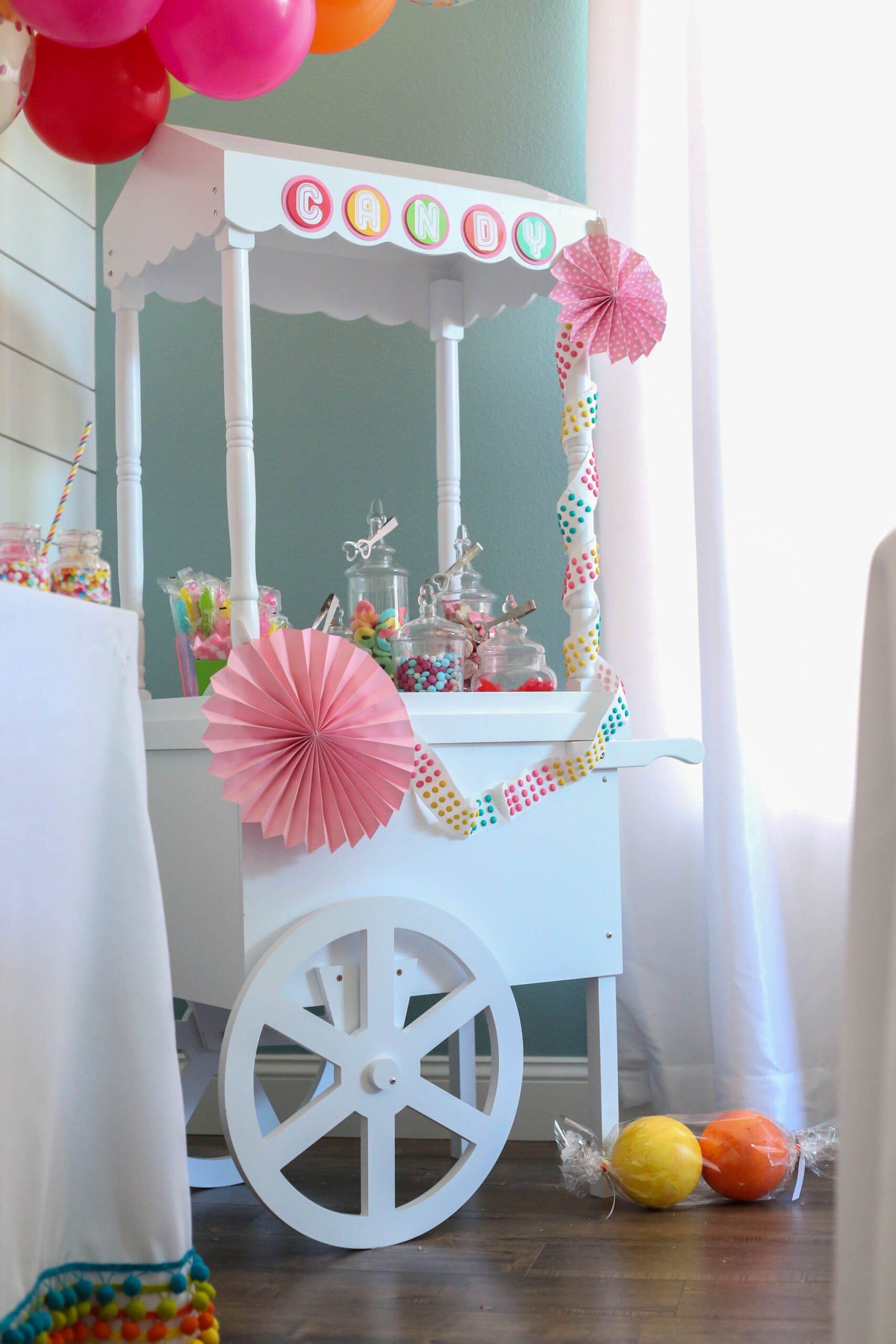 candy cart decorated for a sweet rainbow themed candy party