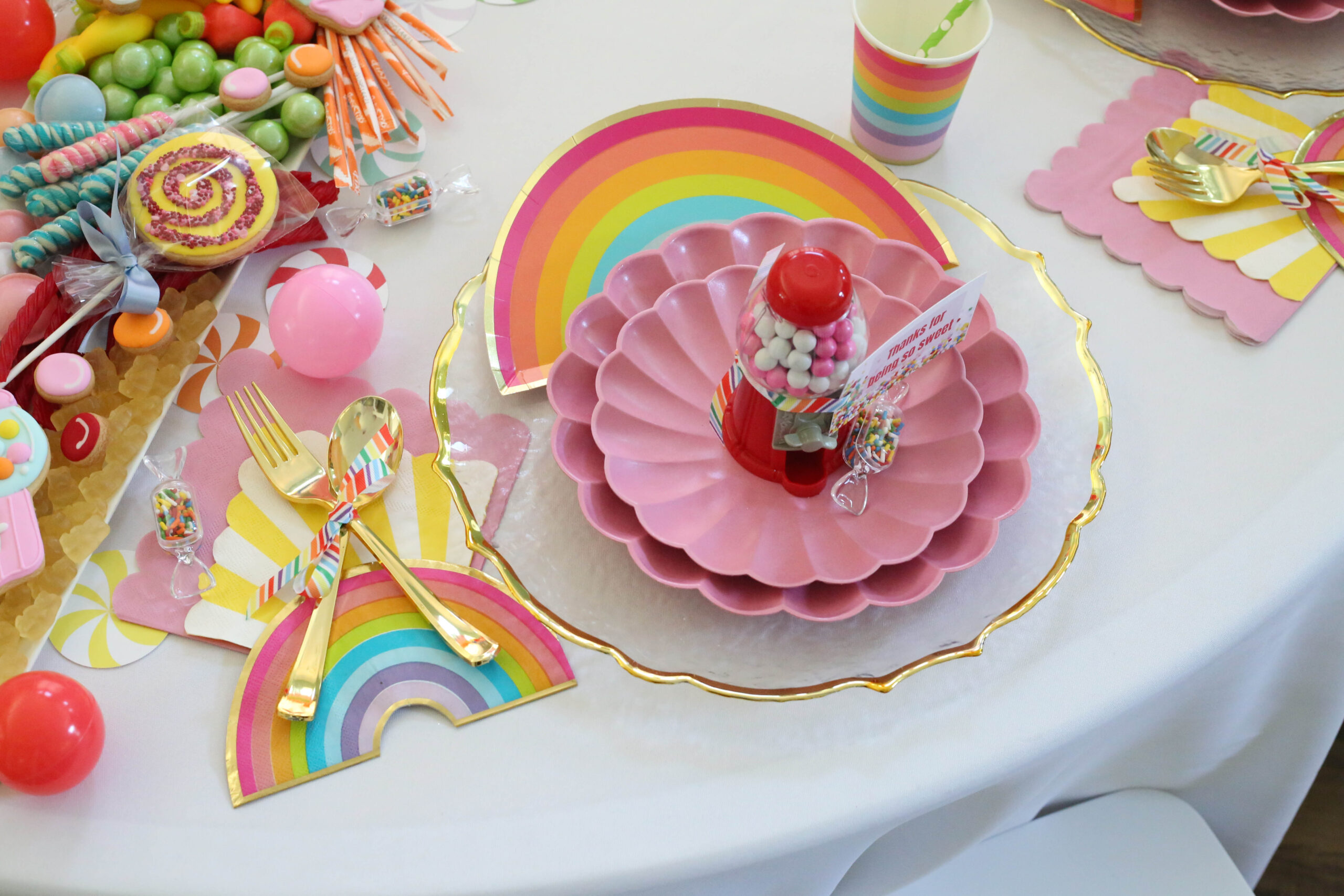 candy party place setting at a round table with a white table cloth