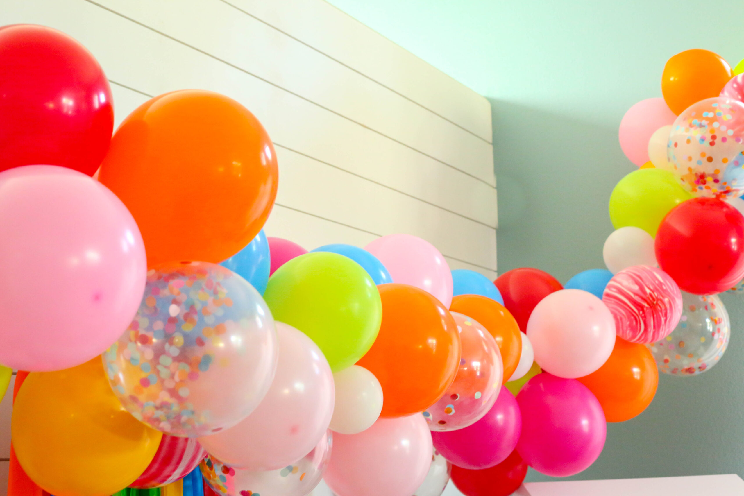 extra long balloon garland with confetti balloons and red marble balloons